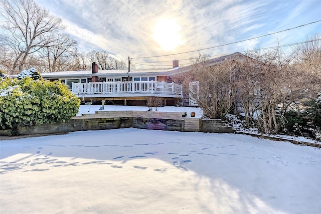 snow covered rear of property featuring a wooden deck