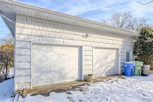 snow covered garage featuring a detached garage