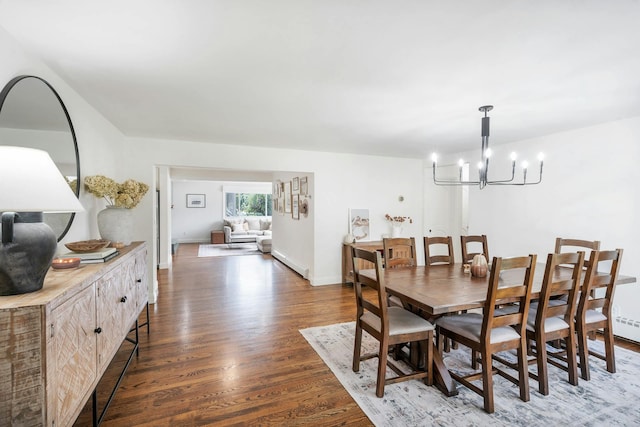 dining room with an inviting chandelier and dark wood-type flooring