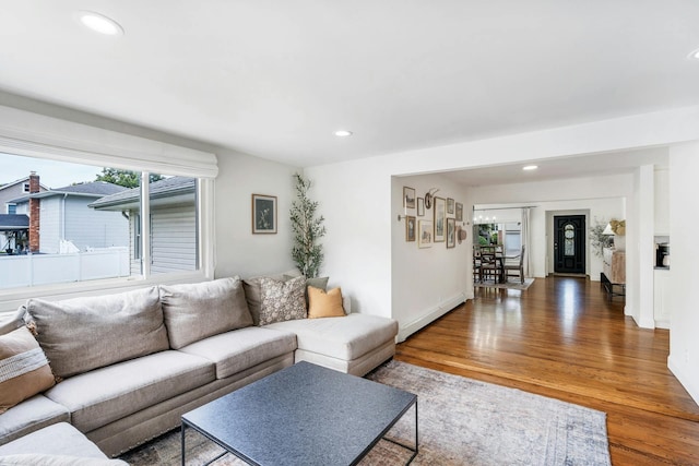 living room with wood-type flooring and a baseboard heating unit