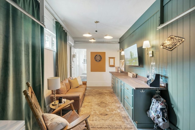 interior space featuring butcher block counters, decorative light fixtures, a wall mounted AC, and wood walls