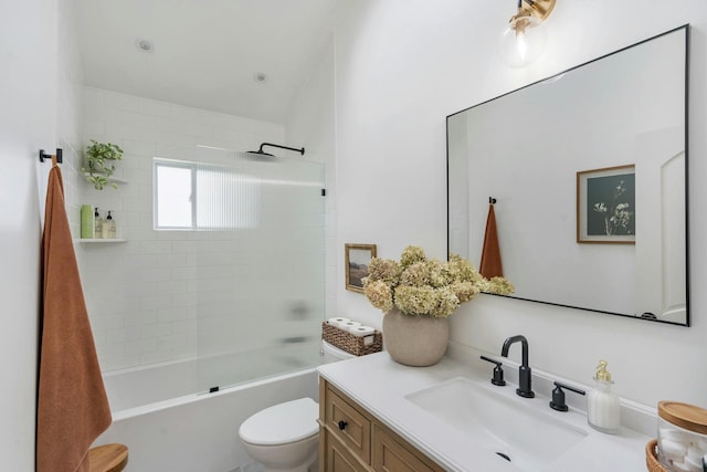 full bathroom featuring tiled shower / bath combo, vanity, and toilet