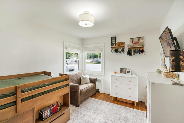 bedroom with radiator and light hardwood / wood-style floors