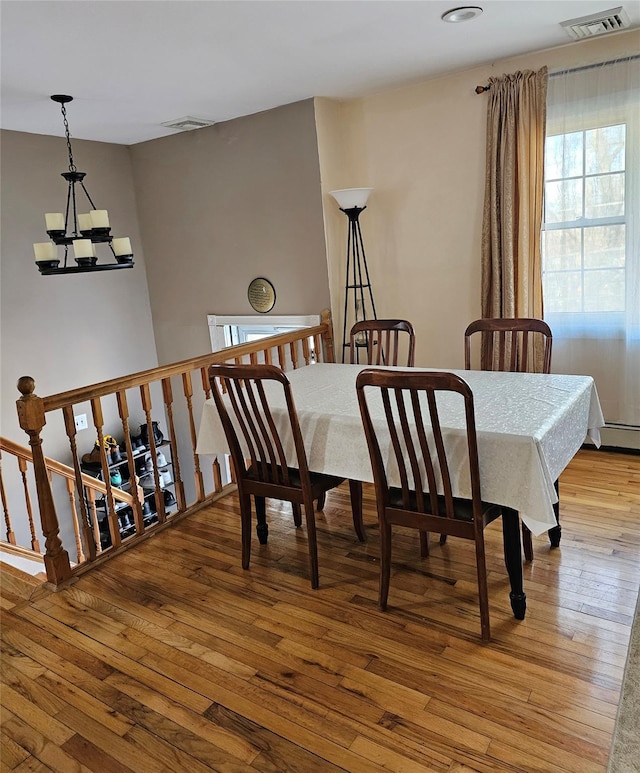 dining area featuring baseboard heating, a chandelier, and light hardwood / wood-style floors