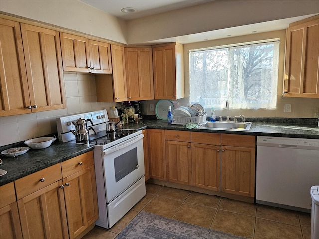 kitchen featuring sink, white appliances, decorative backsplash, and dark tile patterned floors