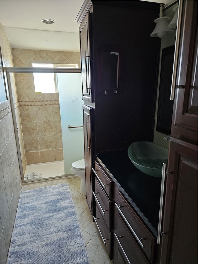 bathroom featuring walk in shower, vanity, tile patterned floors, and toilet