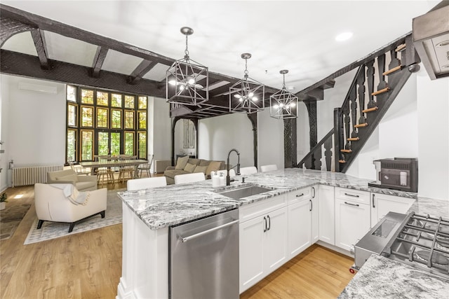 kitchen with sink, white cabinetry, hanging light fixtures, stainless steel appliances, and light stone countertops