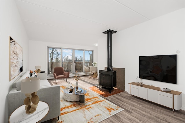 living room with a wood stove and hardwood / wood-style floors