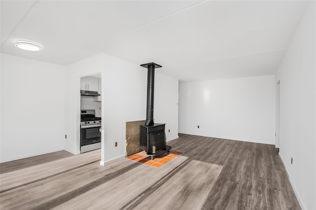 unfurnished living room featuring hardwood / wood-style flooring and a wood stove