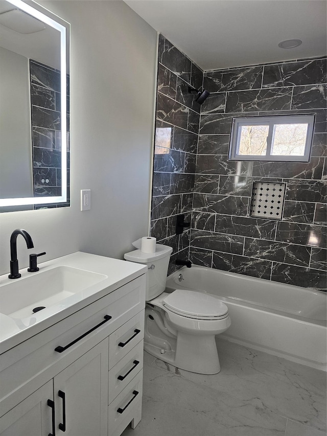 bathroom with marble finish floor, toilet, bathing tub / shower combination, and vanity