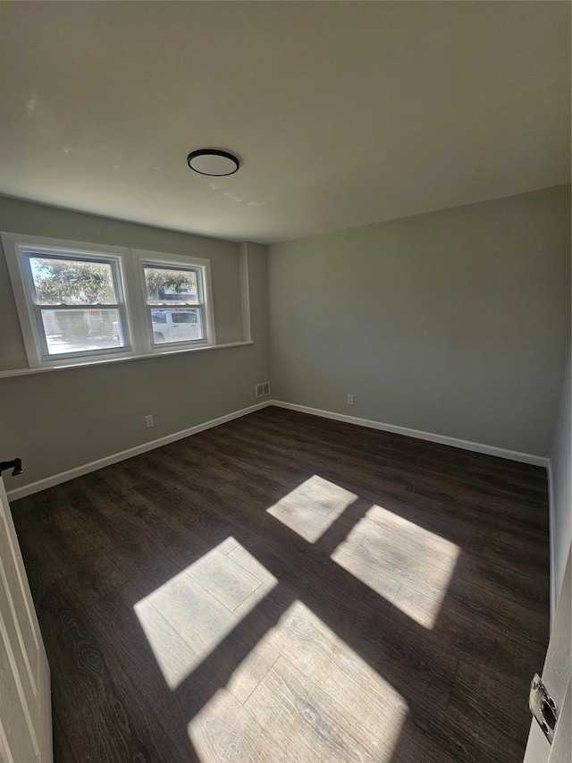 interior space featuring dark wood finished floors, visible vents, and baseboards