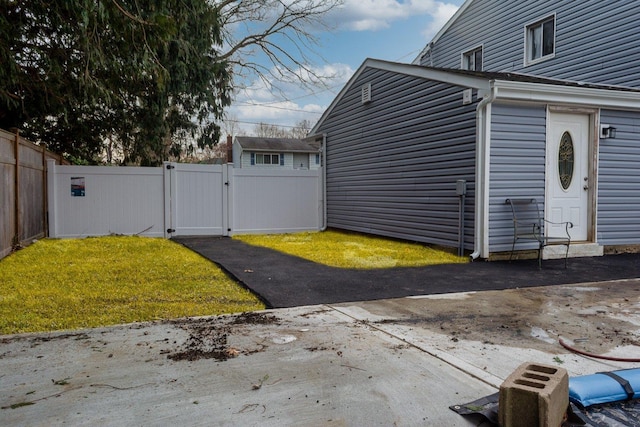 view of property exterior with a gate, fence, and a lawn