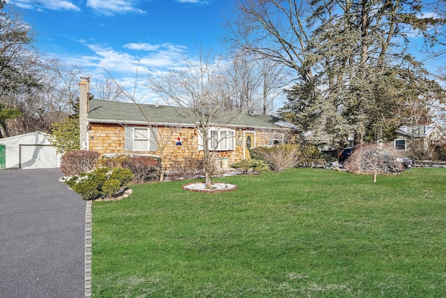 view of front facade featuring a garage, an outdoor structure, and a front lawn