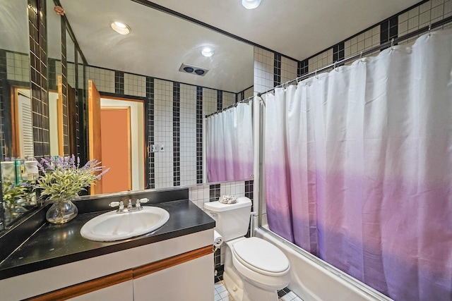 full bathroom with tile patterned floors, toilet, shower / tub combo, tile walls, and vanity