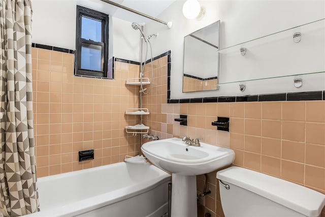 bathroom with tile walls, shower / tub combo with curtain, and toilet