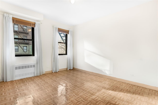 empty room with radiator heating unit and light parquet floors