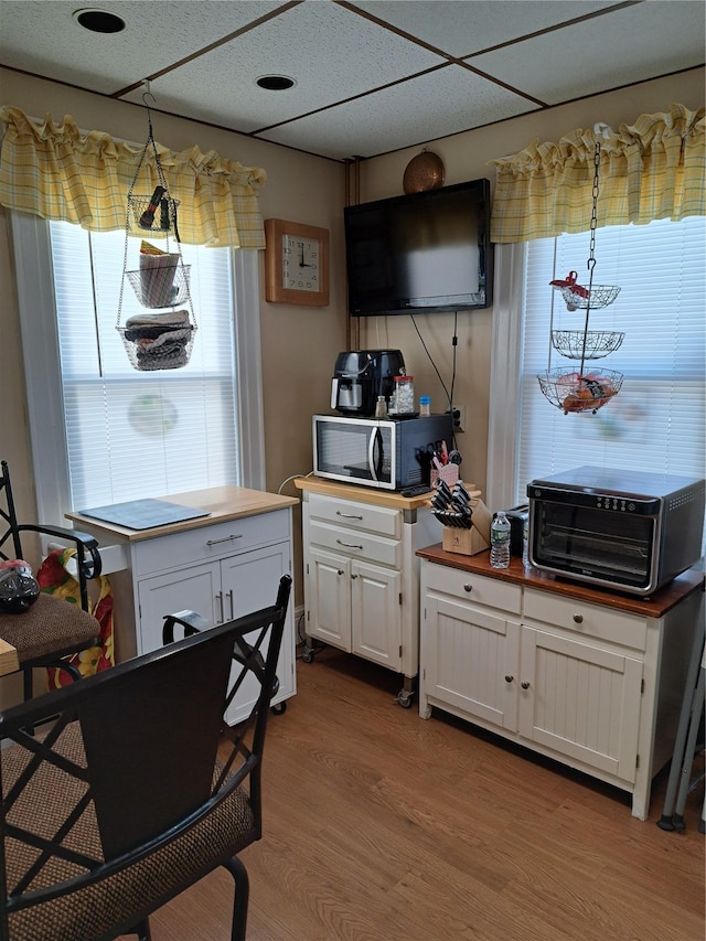 kitchen with white cabinetry, wooden counters, light hardwood / wood-style flooring, and pendant lighting