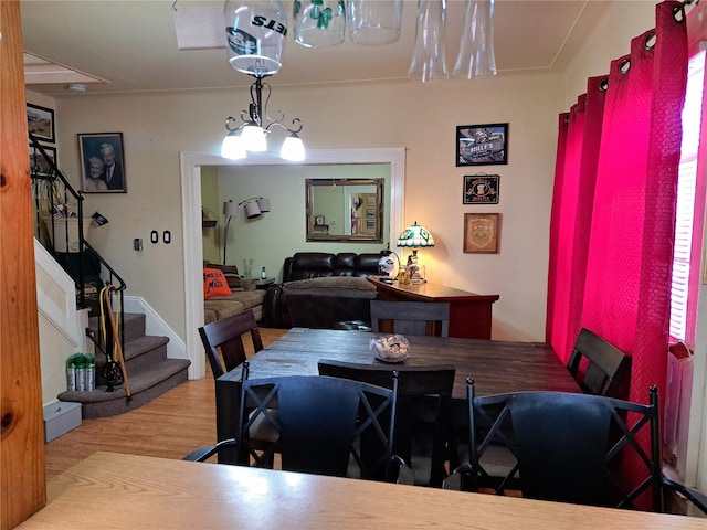 dining space featuring wood-type flooring and a chandelier