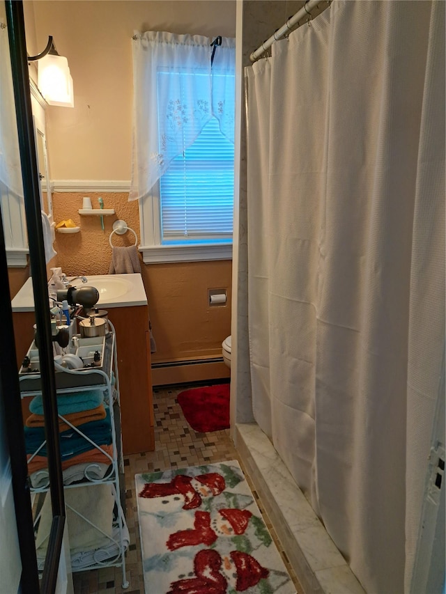 bathroom featuring curtained shower, toilet, a baseboard heating unit, and vanity