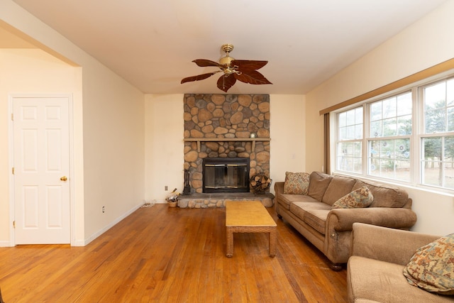 living room with a fireplace, wood-type flooring, and ceiling fan