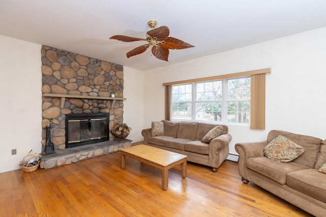 living room with a fireplace, hardwood / wood-style flooring, a baseboard heating unit, and ceiling fan