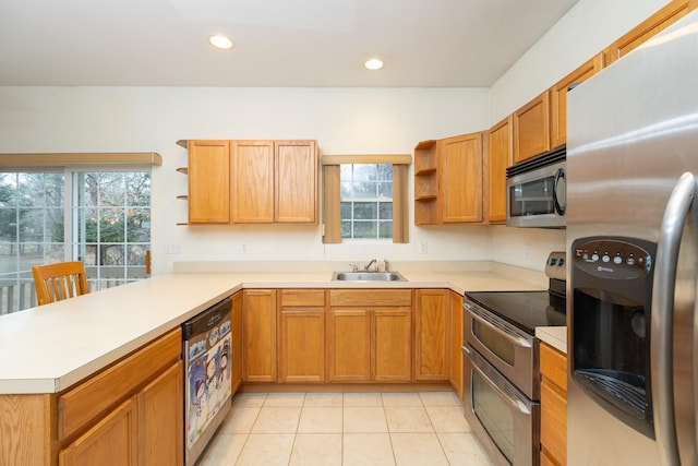 kitchen with kitchen peninsula, sink, light tile patterned floors, and stainless steel appliances