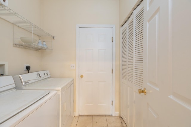 washroom with light tile patterned floors and washer and dryer