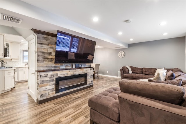 living room featuring a fireplace and light wood-type flooring