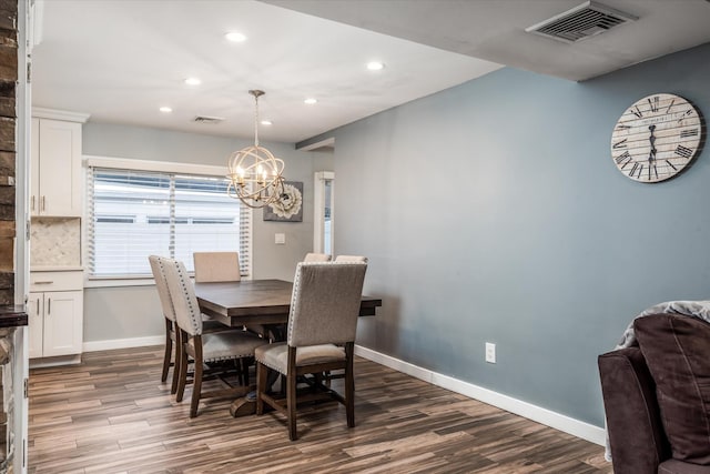 dining room with a notable chandelier and dark hardwood / wood-style flooring