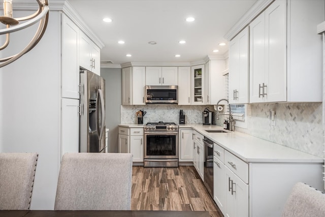 kitchen with white cabinets, stainless steel appliances, tasteful backsplash, sink, and dark hardwood / wood-style floors