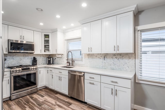 kitchen featuring white cabinetry, dark hardwood / wood-style flooring, stainless steel appliances, tasteful backsplash, and sink