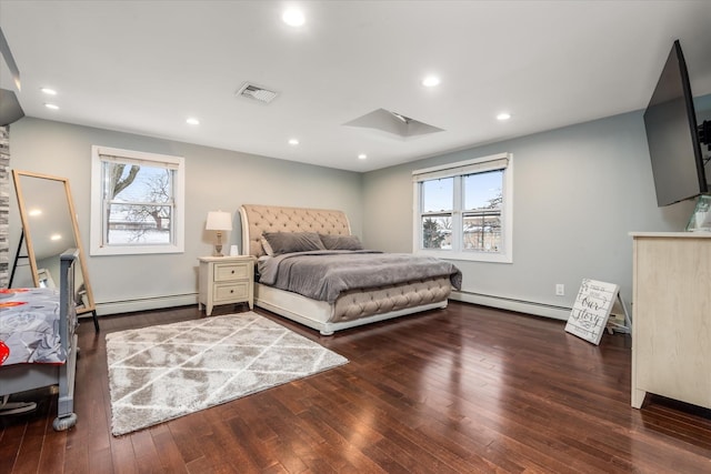 bedroom featuring a skylight, hardwood / wood-style floors, and a baseboard radiator