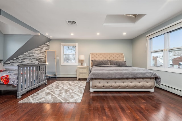 bedroom with dark wood-type flooring, baseboard heating, and vaulted ceiling