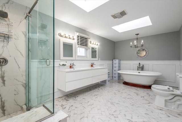 bathroom featuring independent shower and bath, a skylight, and vanity