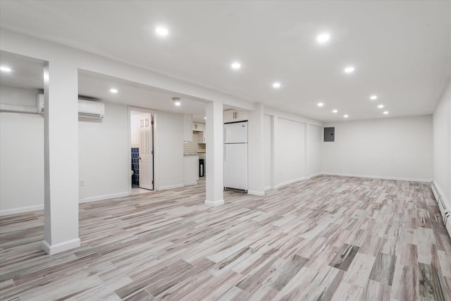 basement with electric panel, a wall mounted air conditioner, light hardwood / wood-style flooring, and white refrigerator