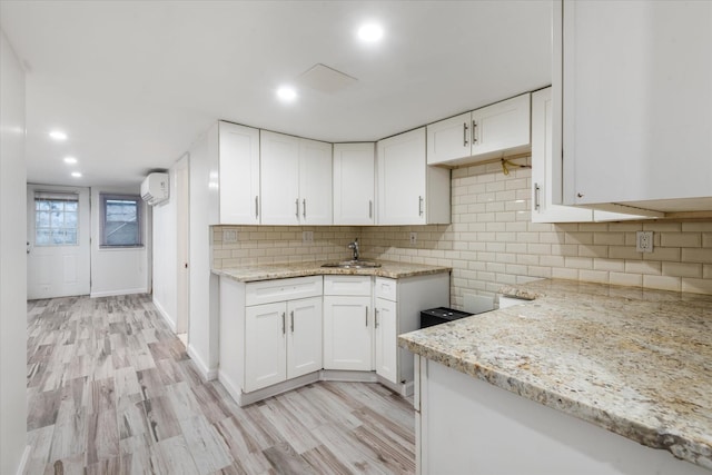 kitchen featuring sink, white cabinets, and light stone countertops