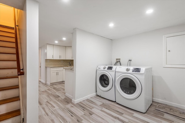 laundry room with light wood-type flooring and washer and clothes dryer