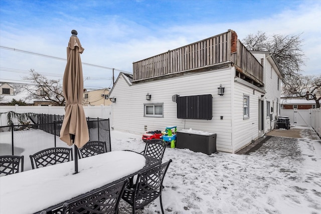 snow covered rear of property with a balcony