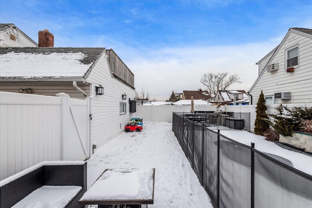 view of snowy exterior with an AC wall unit