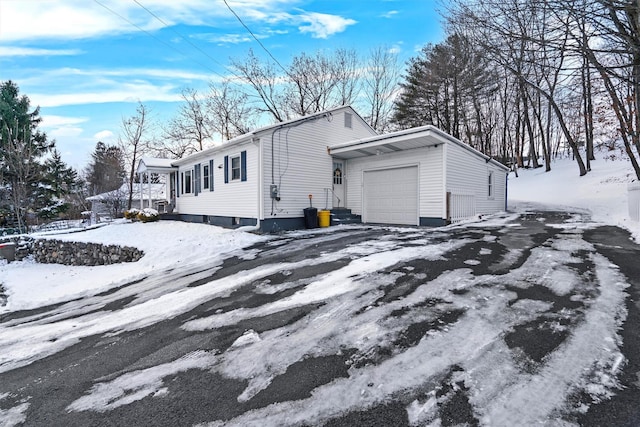 view of snow covered exterior with a garage