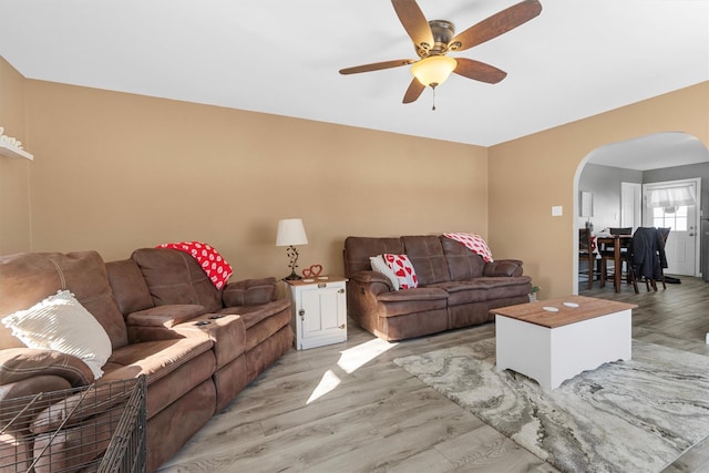 living room with ceiling fan and light hardwood / wood-style flooring