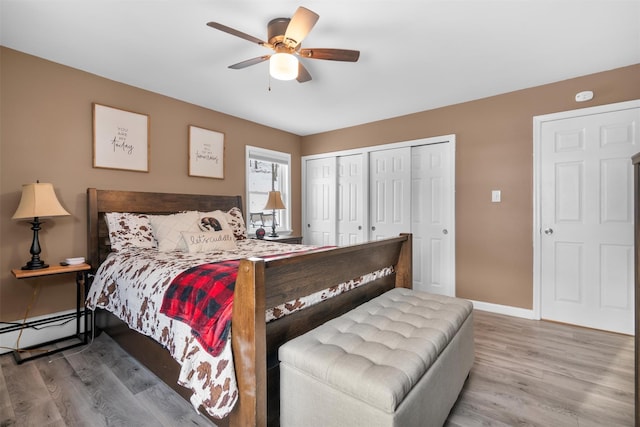 bedroom with ceiling fan, a baseboard radiator, wood-type flooring, and a closet