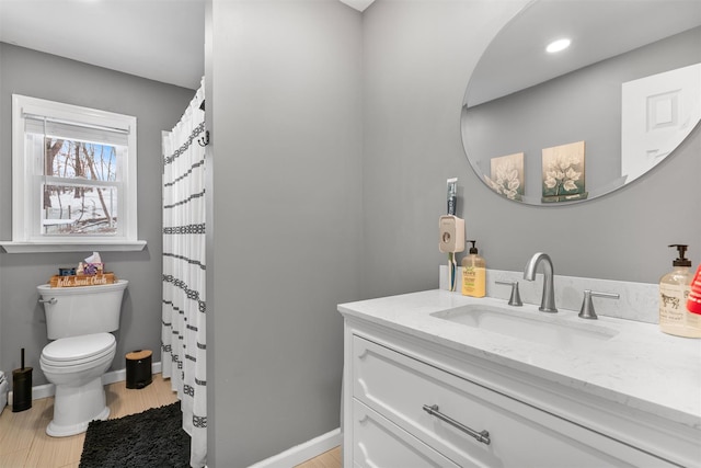 bathroom featuring hardwood / wood-style flooring, vanity, and toilet