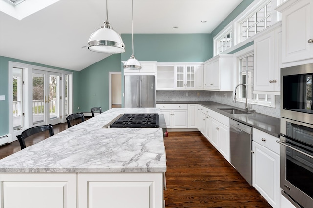 kitchen featuring sink, white cabinetry, tasteful backsplash, decorative light fixtures, and appliances with stainless steel finishes