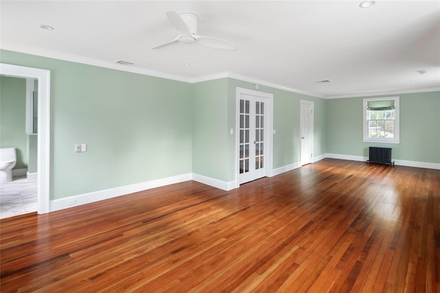 unfurnished living room with hardwood / wood-style flooring, ornamental molding, radiator, and ceiling fan