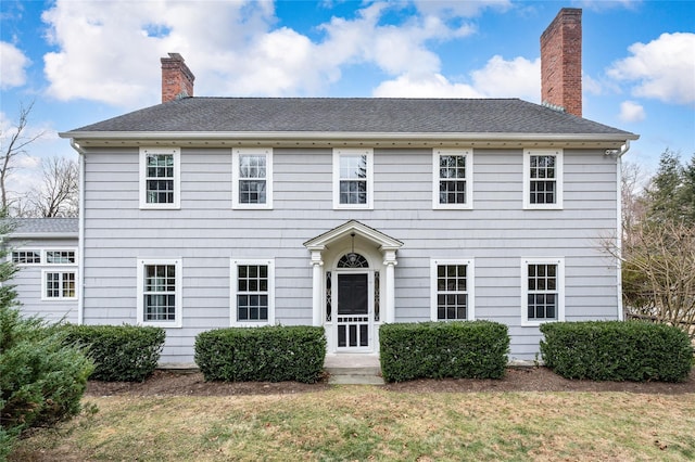 colonial-style house featuring a front lawn