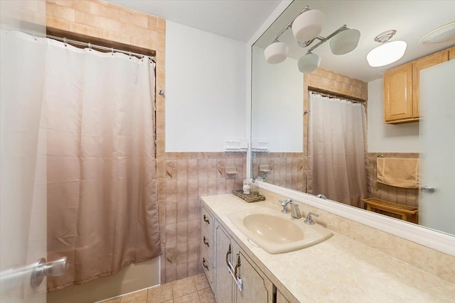 bathroom with tile patterned flooring, vanity, tile walls, and walk in shower