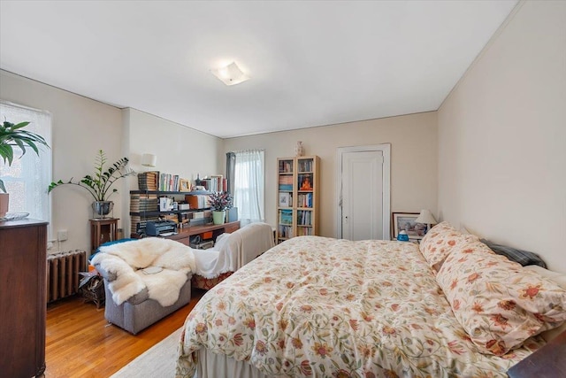 bedroom featuring radiator and light wood-type flooring