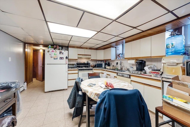 kitchen with backsplash, a drop ceiling, white cabinets, and white appliances