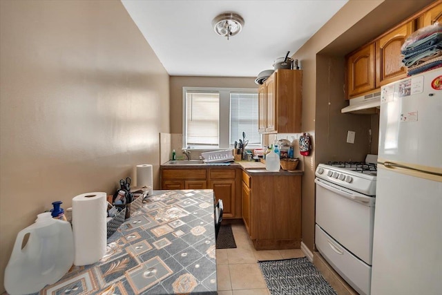 kitchen with white appliances, sink, and light tile patterned floors